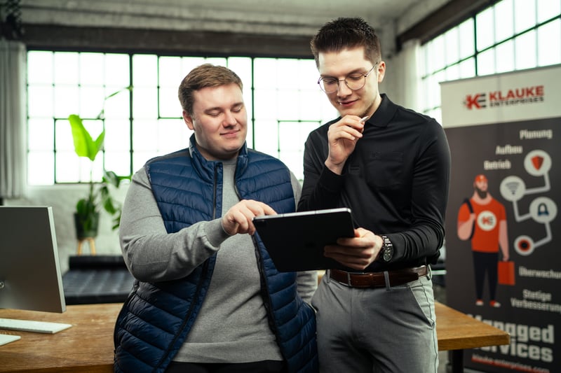 Zwei Mitarbeiter planen gemeinsam an einem Tablet